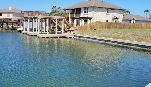 Bottom level canal water front home with spacious deck, boat dock, and parking!