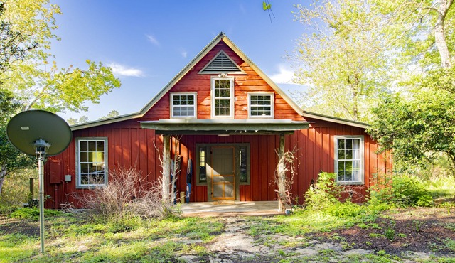 Private cabin built over a lake with a large breezy screened-in porch.